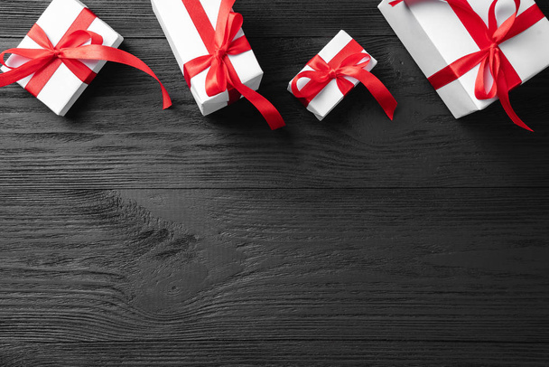 Karácsonyi ajándékok a sötét fából készült rusztikus háttér, szöveg hely kártya. Karácsonyt és boldog új évet üdvözlő kártya. Felülnézet, lapos laikus.  - Fotó, kép