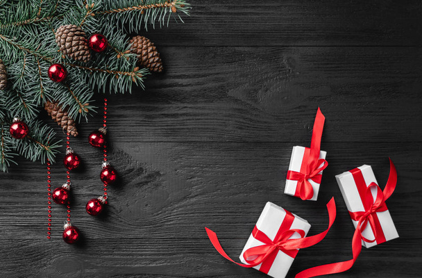 Carte de Noël avec cadeaux blancs et branches de sapin sur un fond rustique en bois foncé, lieu de texte. Noël et bonne année carte de vœux. Vue de dessus, plan plat
.  - Photo, image