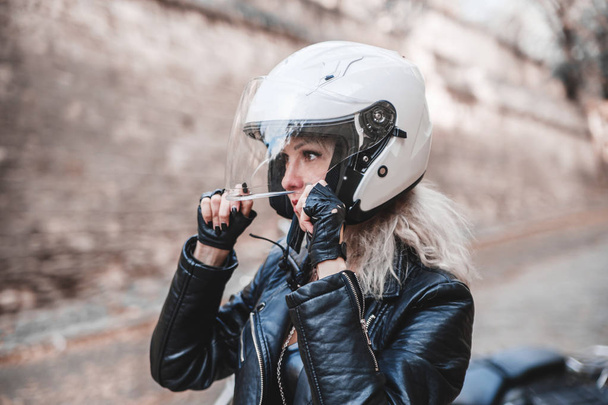 Beautiful biker woman posing outdoor with motorcycle.  - Photo, Image