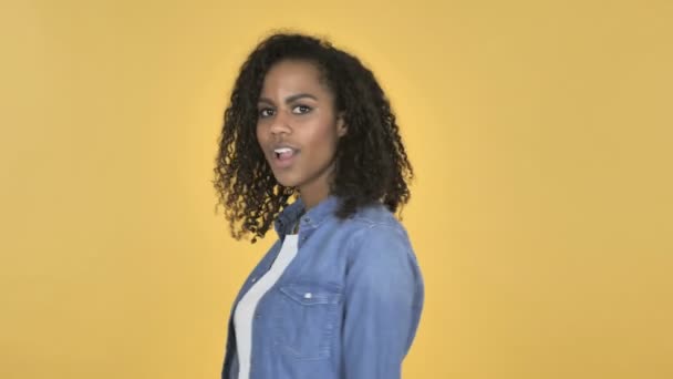 Stupito ragazza africana sorpreso mentre Truing intorno isolato su sfondo giallo
 - Filmati, video