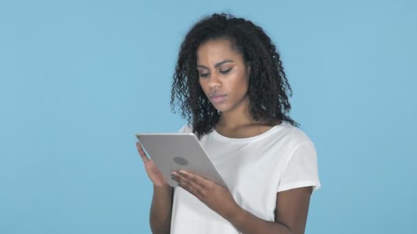 African Girl in Shock while Using Tablet Isolated on Blue Background - Imágenes, Vídeo
