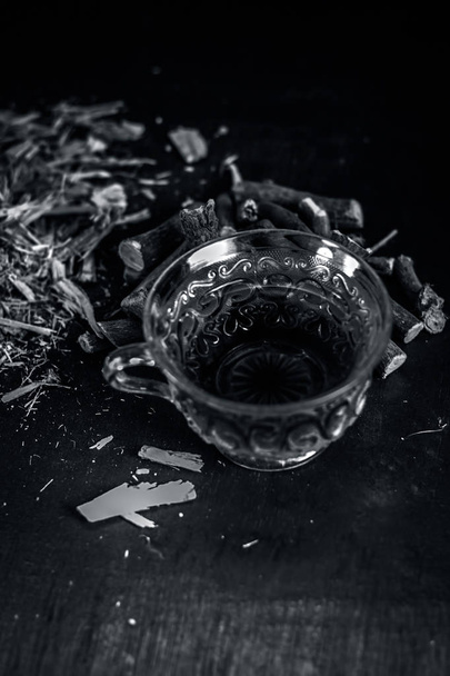 Close up of tea with liquorice roots on wooden background - Valokuva, kuva