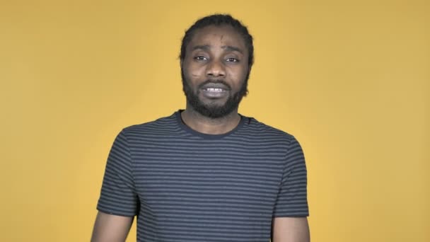 Casual African Man Gesturing Thumbs Down Isolated on Yellow Background - Filmati, video