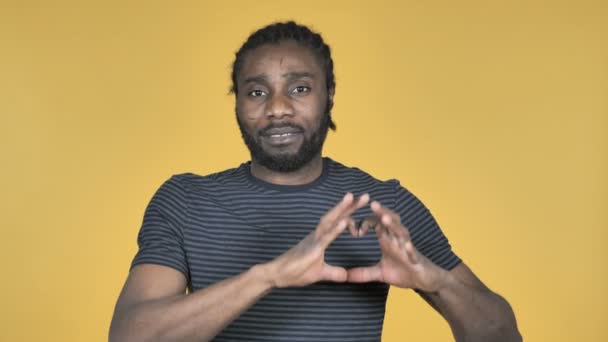 Handmade Heart by Casual African Man Isolated on Yellow Background - Πλάνα, βίντεο