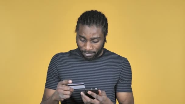 Online Shopping on Smartphone by Casual African Man Isolated on Yellow Background - Filmagem, Vídeo