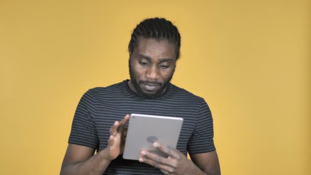 Casual African Man Excited for Success while Using Tablet Isolated on Yellow Background - Video
