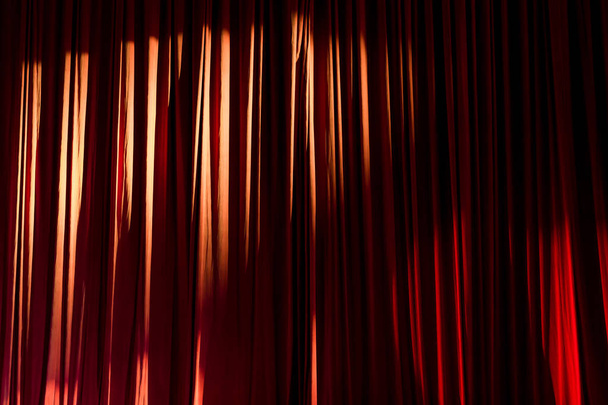 Червоні штори і прожектор в театрі між шоу
. - Фото, зображення