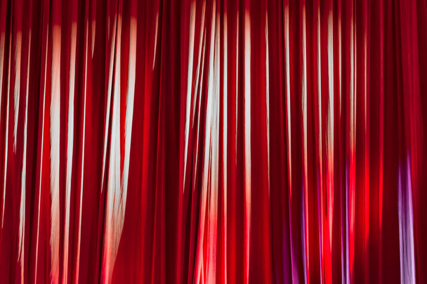 Κόκκινες κουρτίνες και τα φώτα της δημοσιότητας στο θέατρο ανάμεσα στις παραστάσεις. - Φωτογραφία, εικόνα