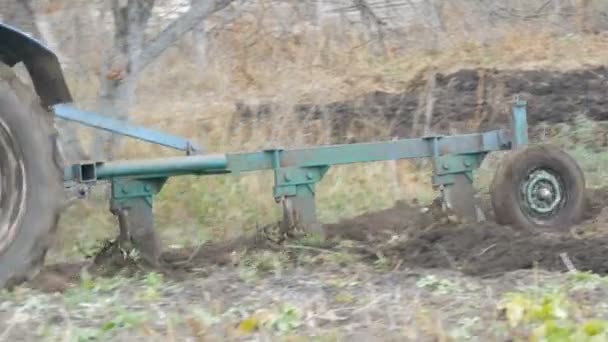 A blue tractor plows black soil in deep autumn. Winter ground preparation - Footage, Video