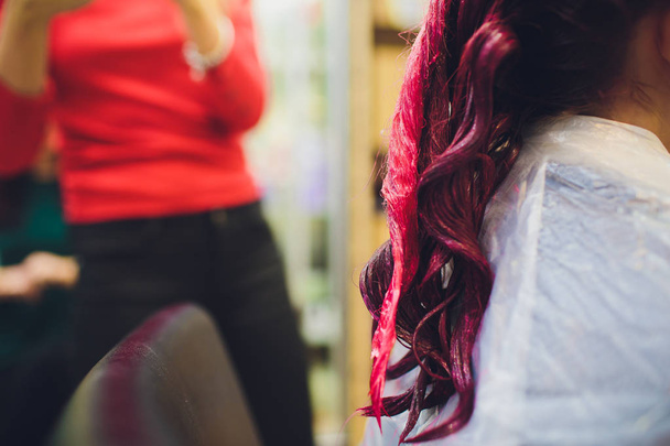 Beautician dying hair of woman. Girl in beauty salon. - Foto, afbeelding