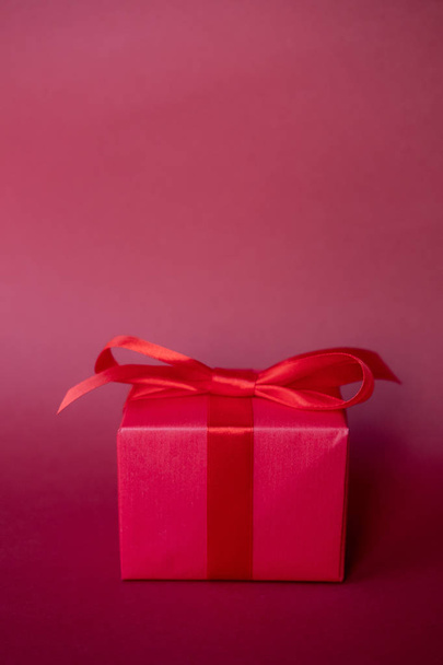 Red gift box on red background.  Copy space. - 写真・画像