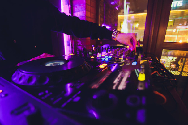 DJ kezét a távirányítón. nightclub. DJ ellenőrzése és mozog a keverők, a zene távoli. - Fotó, kép