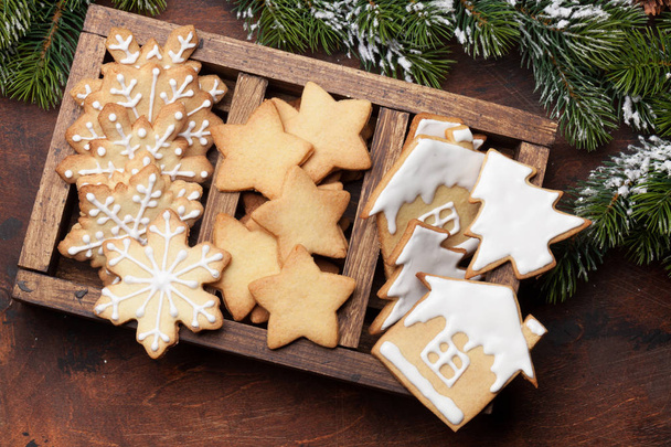 Χριστουγεννιάτικη κάρτα με μελόψωμο cookies και ελάτης κλαδί δέντρου που καλύπτονται από χιόνι σε ξύλινο υπόβαθρο. Το Top view - Φωτογραφία, εικόνα