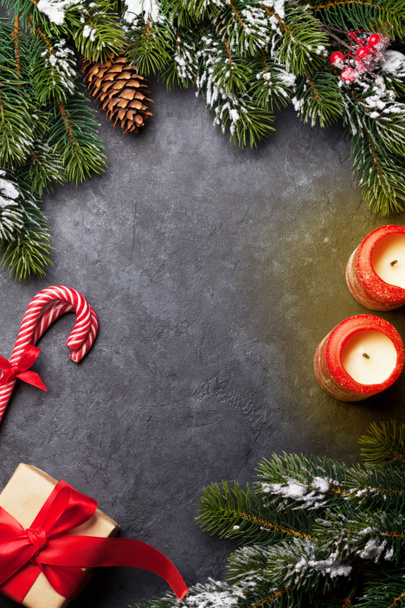 Різдвяна листівка з цукерками, подарунковою коробкою та гілкою ялинки на кам'яному фоні. Вид зверху тло з пробілом для ваших привітань. Плоский прошарок
 - Фото, зображення