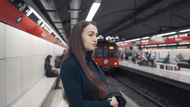 Mladá dívka stojící na platformě a čekání vlak s - Záběry, video