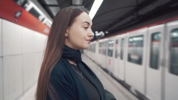 Νεαρό κορίτσι στέκεται στην πλατφόρμα και περιμένουν το τρένο για να φτάσετε - Πλάνα, βίντεο
