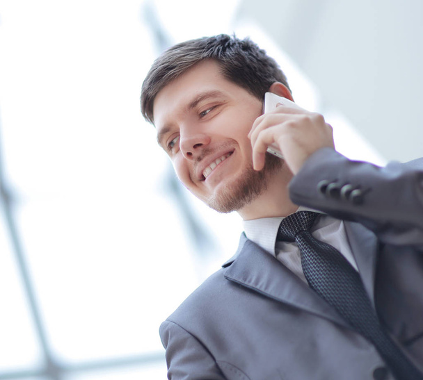 close up.smiling businessman talking on mobile phone - Fotó, kép