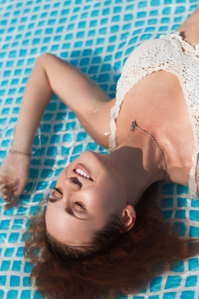 sexy girl takes a sunbath in the swimming pool - Fotoğraf, Görsel