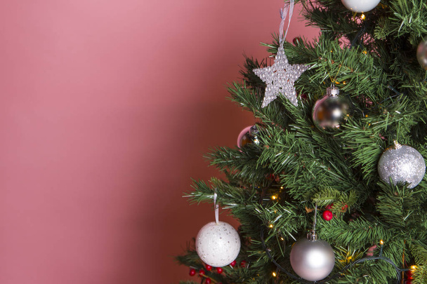 διακοσμημένο χριστουγεννιάτικο δέντρο σε φόντο ροζ τοίχο - Φωτογραφία, εικόνα