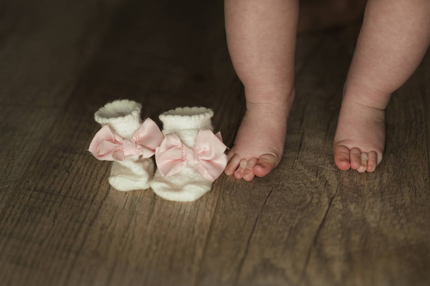 legs of newborn baby close up on wooden background - Foto, immagini