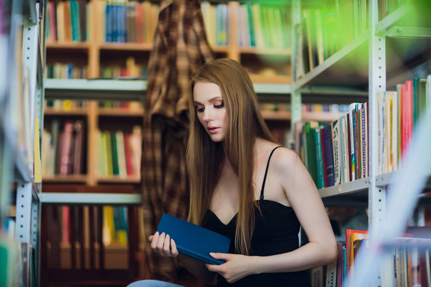 Beautiful female student in university library - Valokuva, kuva