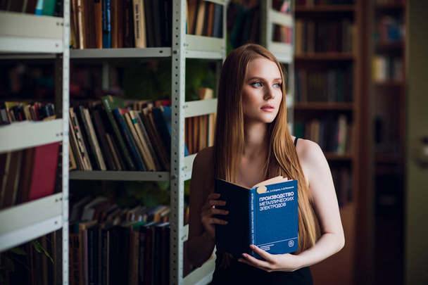 Beautiful female student in university library - Foto, afbeelding