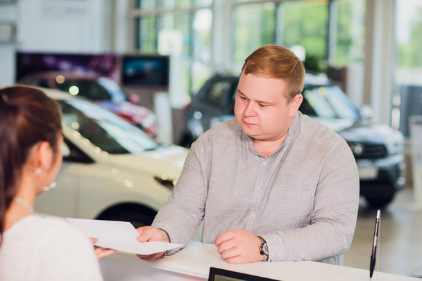successful businessman in car dealership - sale of vehicles to customers - Foto, Imagen