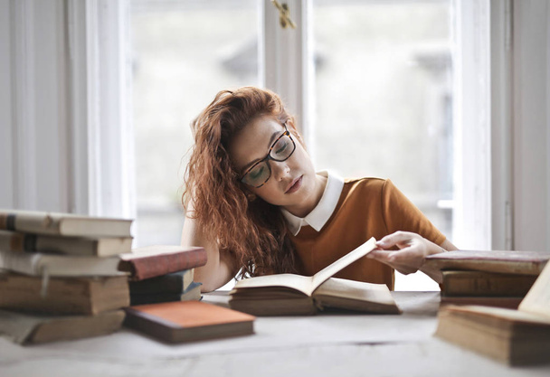 Young woman reading books in library - Foto, Bild