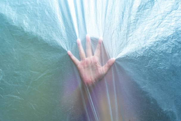 Abstract texture and background of hand push the plastic sheet from behind. Stop using plastic campaign. Reduce, Reuse, Recycle concept. Stop Global warming - Photo, Image
