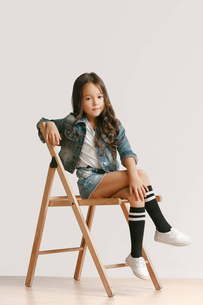Full length portrait of cute little kid in stylish jeans clothes looking at camera and smiling - Photo, Image