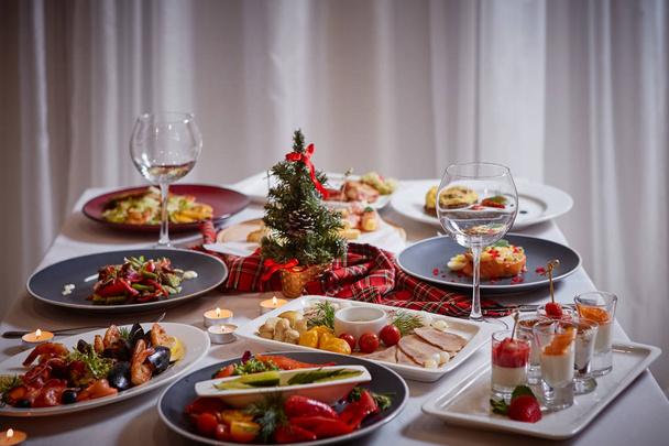 Christmas themed dinner table with a variety of appetizers and salads - Fotó, kép