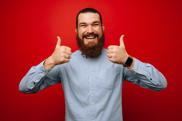 Cheerful bearded hispter man in casual showing thumbs up - Фото, изображение