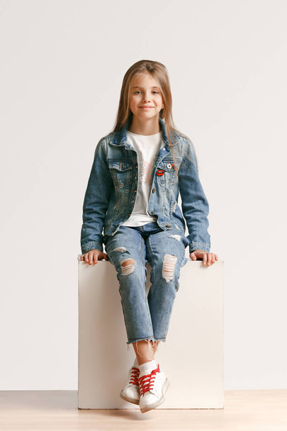 Full length portrait of cute little teen in stylish jeans clothes looking at camera and smiling - Фото, зображення