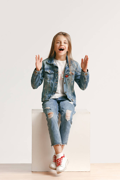 Full length portrait of cute little teen in stylish jeans clothes looking at camera and smiling - Zdjęcie, obraz
