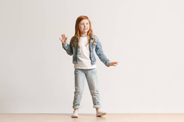 Full length portrait of cute little kid in stylish jeans clothes looking at camera and smiling - Zdjęcie, obraz