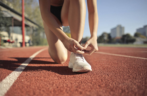 Giovane atleta femminile legando i suoi sholaces in gara
 - Foto, immagini