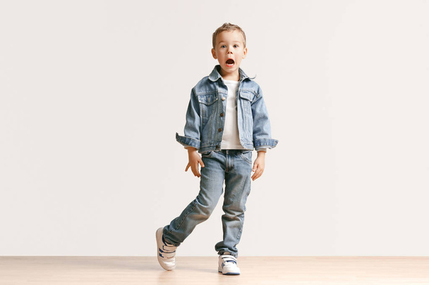 The portrait of cute little boy in stylish jeans clothes looking at camera at studio - Valokuva, kuva