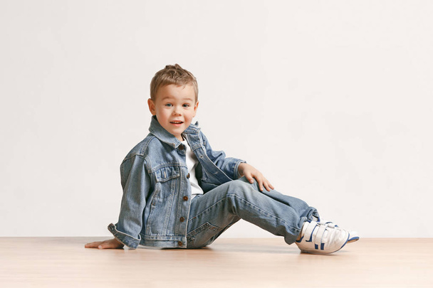 The portrait of cute little boy in stylish jeans clothes looking at camera at studio - Foto, Imagen