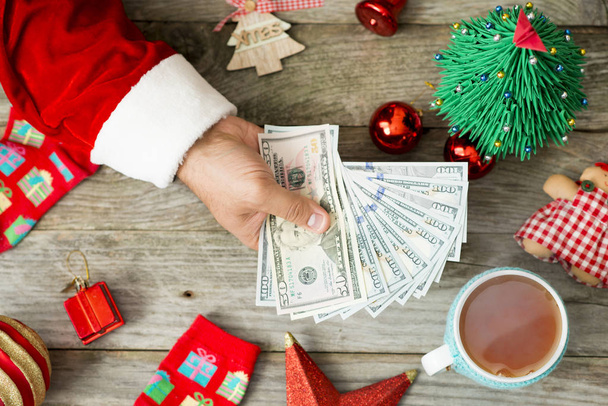 Noel Baba el Noel çerçevede, tatil sırasında yüksek giderleri düşündüren nakit para tutarak - Fotoğraf, Görsel