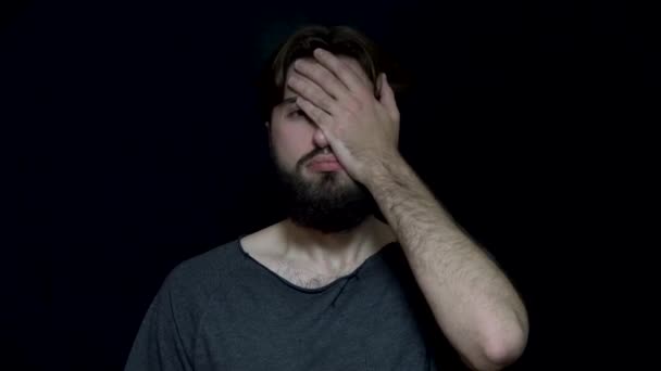 Man with beard covered his face with his hand. Frustrated and tired young man with beard covers face with hand. Human feelings and emotions - Footage, Video