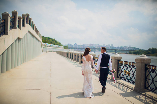 stylish bride and groom posing on the background of the river. - Photo, image