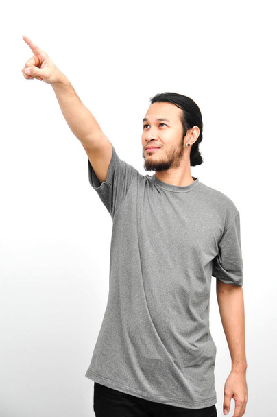 sonriente asiático hombre con largo cabello apuntando arriba en blanco fondo
 - Foto, Imagen