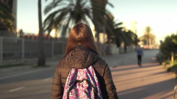 Tyttö turisti reppu selässään kävelee pitkin kämmen promenade
 - Materiaali, video