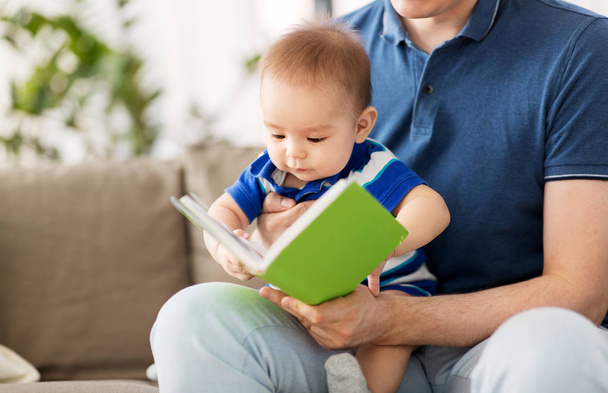 baby boy and father with book at home - Photo, image