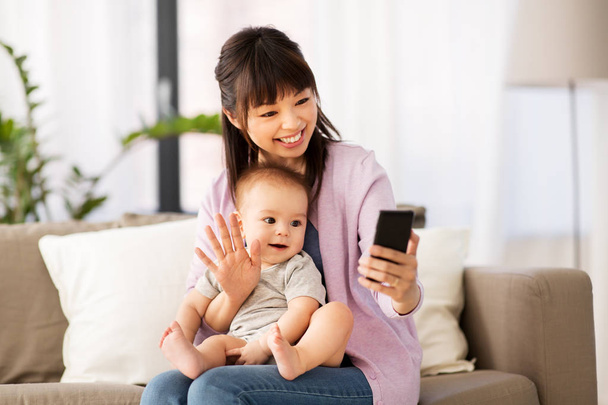 asian mother with baby son taking selfie at home - Foto, Imagen