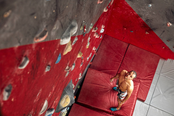 Panoramic man bouldering at an indoor climbing centre. - Foto, Bild