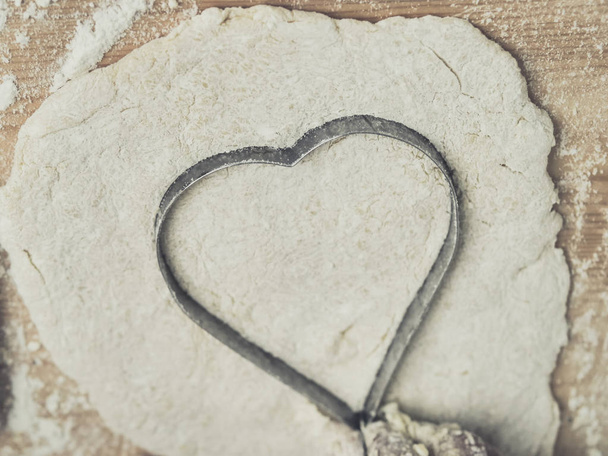 Girl hands molding heart shape dough on table, lifestyle concept. - Foto, immagini