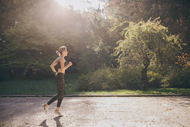 Runner woman running in park exercising outdoors fitness tracker wearable technology - 写真・画像