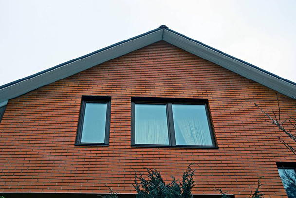 ventanas en la pared del ático de ladrillo marrón contra el cielo
 - Foto, Imagen
