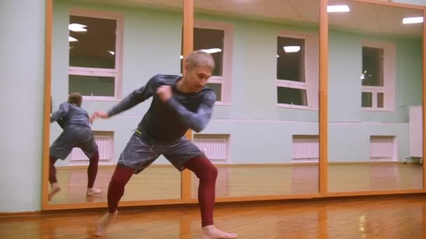 Stíhací provádí bojové triky s taneční prvky v tělocvičně sportovní - Záběry, video